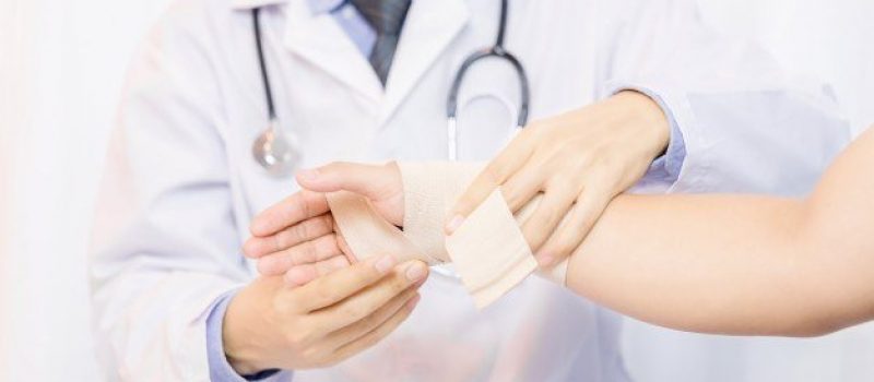male-doctor-putting-gauze-young-man-s-hand-clinic-closeup-first-aid_1150-12970